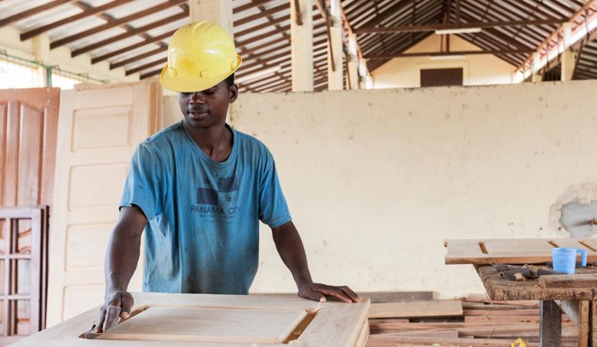 A Sasfino craftsman finishing a timber board by hand